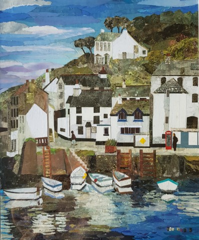 Polperro Harbour with white buildings and fishing boats on the sea